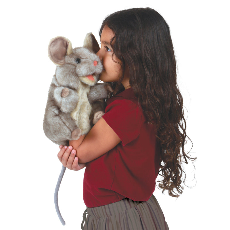 Young girl kissing a plush mouse toy on a white background