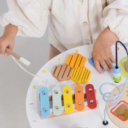 Child playing with a colorful wooden toy on a white surface