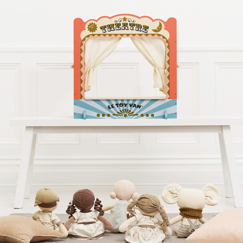Children's playset with dolls sitting in front of a toy theater.