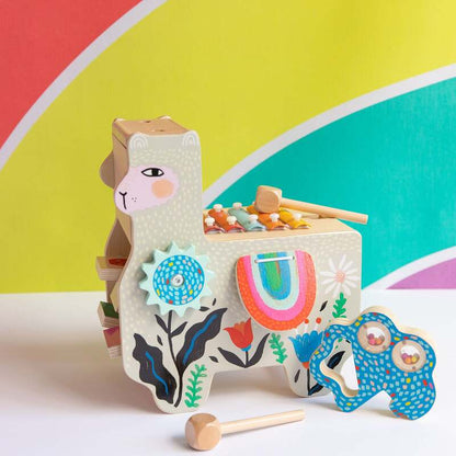 Wooden toy llama with colorful patterns and accessories on a multicolored background