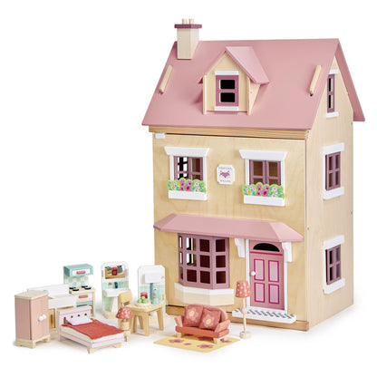 Toy dollhouse with pink roof and detailed furniture on a white background