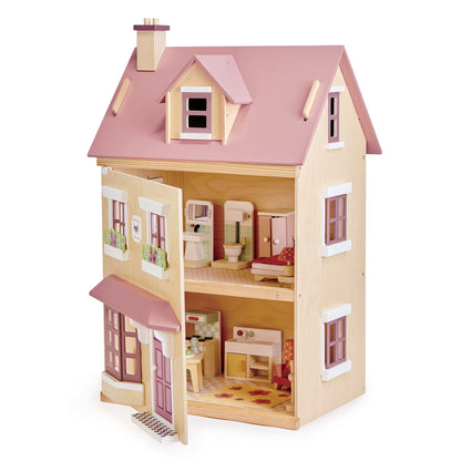 Wooden dollhouse with pink roof and detailed interior on a white background