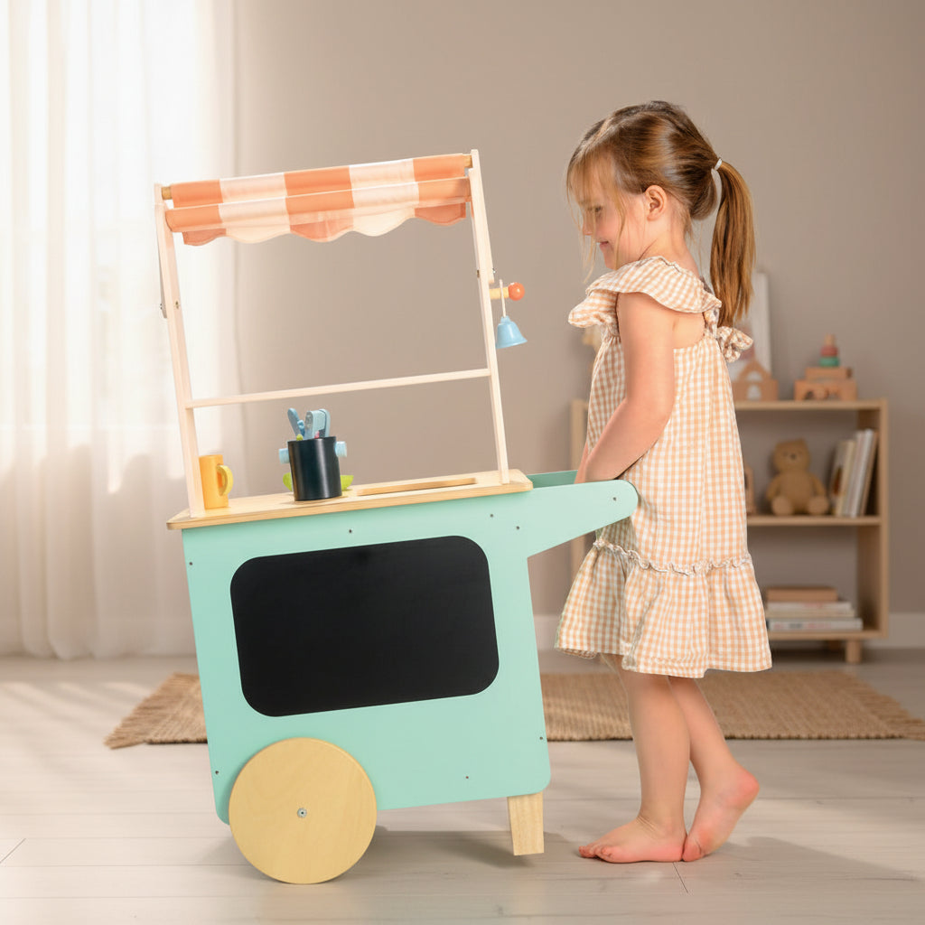 Child playing with a toy kitchen cart on a white background