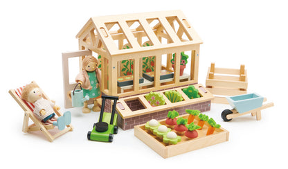 Wooden toy garden set with a greenhouse, tools, and vegetables on a white background