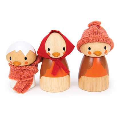 Three wooden dolls with colorful hats and scarves on a white background