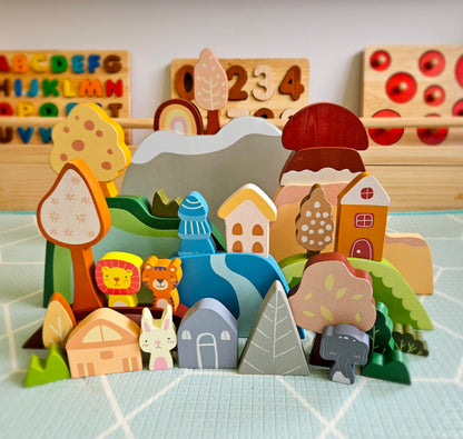 Set of wooden toys including houses, animals, and a landscape on a checkered surface.
